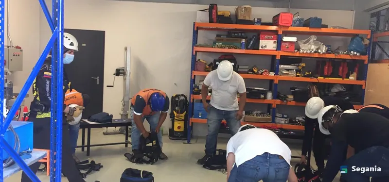 Trabajadores revisando arneses y equipo de protección